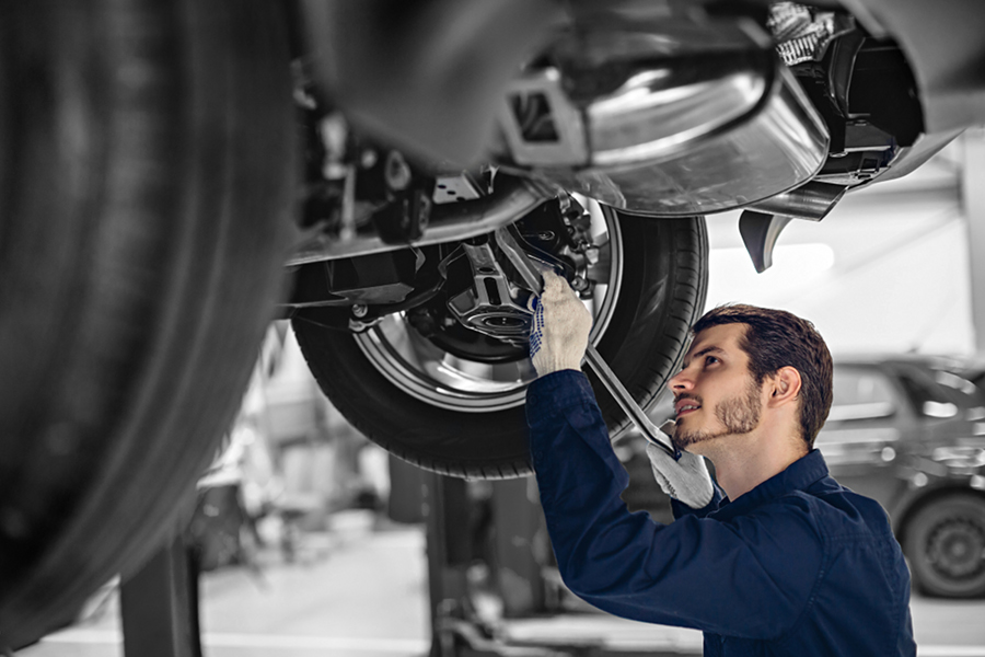 Auto mechanic examining car suspension