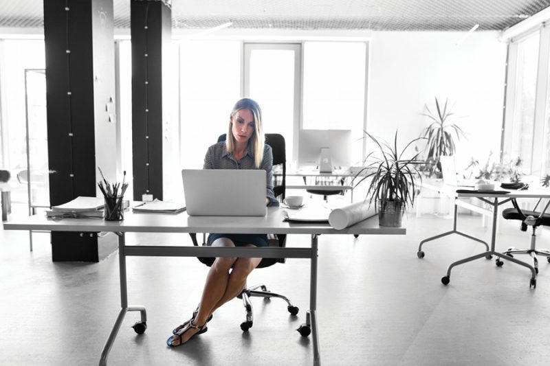 businesswoman with laptop working at a desk in her office