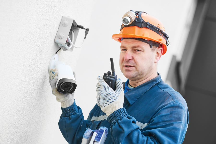 Technician adjusting wall surveillance camera